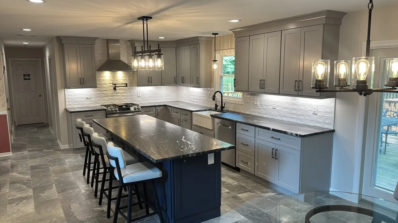 A remodeled kitchen with white cabinets and a gray island