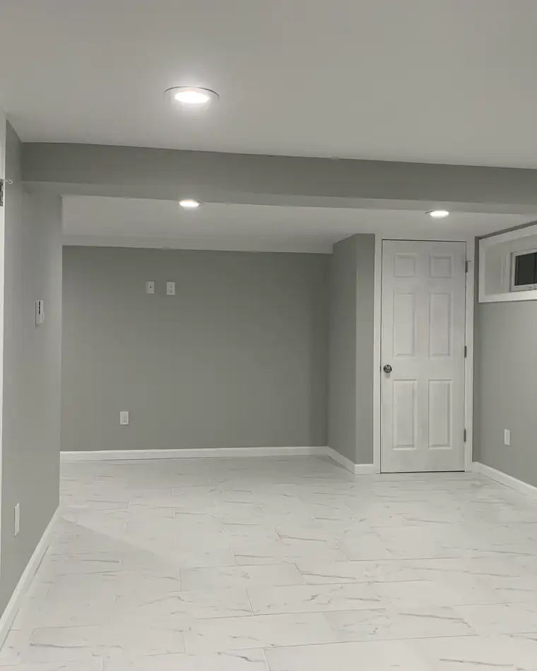 A finished basement with recessed lights and a tile floor
