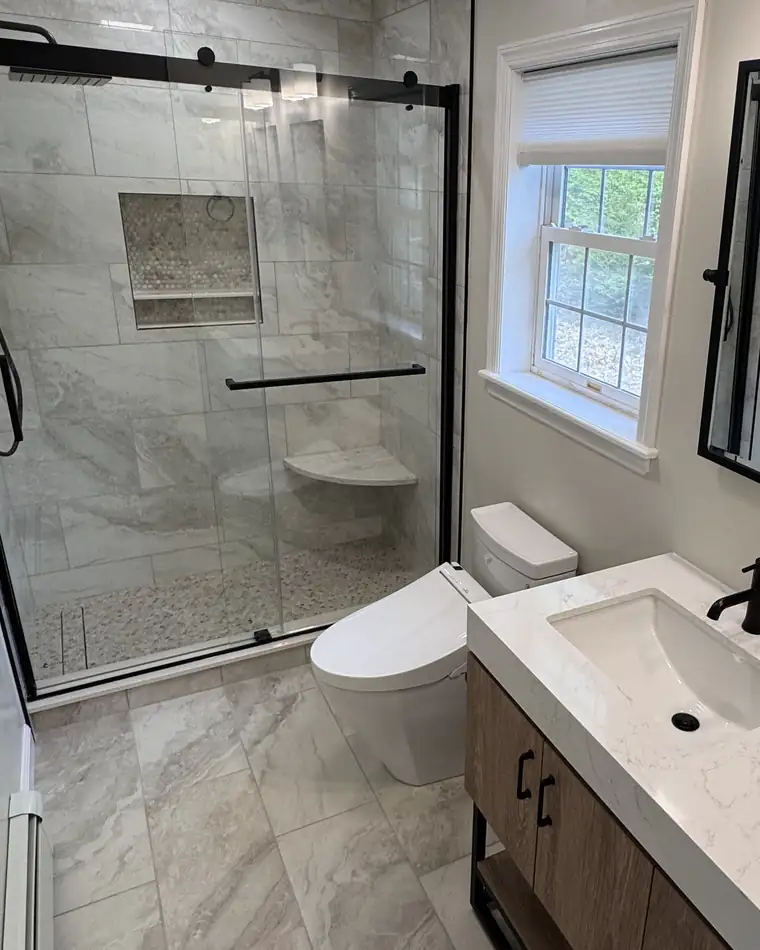 A remodeled main bathroom in Wanaque with a glass shower and a black-framed mirror